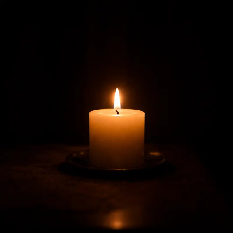 Una vela encendida en la oscuridad de la noche, pequeña y firme, la luz suficiente para el siguiente paso aunque no alcance para ver el horizonte, la fe que persiste aunque el corazón pida irse