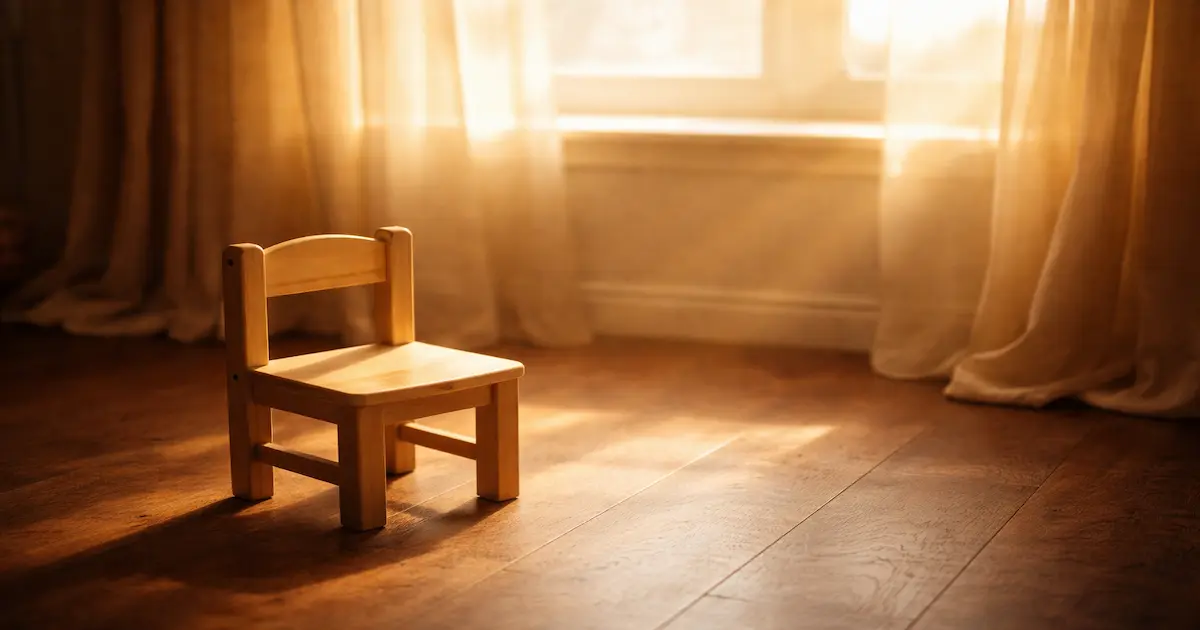 Luz suave entrando por una ventana sobre una silla pequeña vacía, símbolo del espacio que deja un hijo que partió